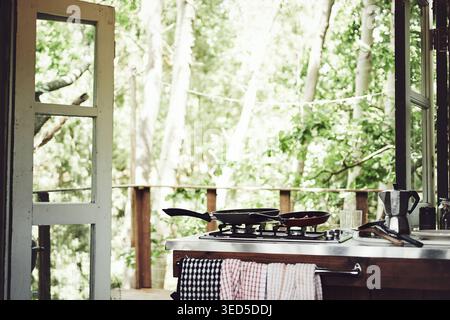 Küche, Haus oder Hütte im Wald für Reisen mit Innenraum, Herd oder Kochbereich. Balkon, Haus oder Ferienhaus im Wald mit Herd im Zimmer Stockfoto