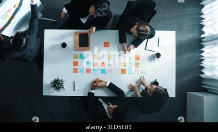 Top-Down-Ansicht eines professionellen Geschäftsmannes Finden Sie eine Lösung, während Sie mithilfe von Haftnotizen eine Idee mit der Führungskraft zusammenstellen. Gruppe von Diversität Stockfoto