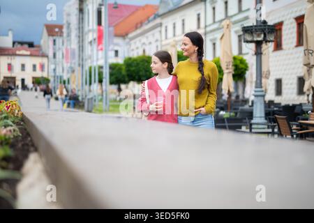 Mutter und Tochter gehen in die Stadt und reden. Stockfoto