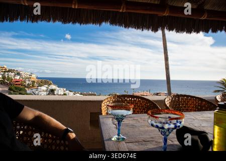 Margaritas auf einer Terrasse am Meer mit Blick auf den sonnigen Ozean Stockfoto