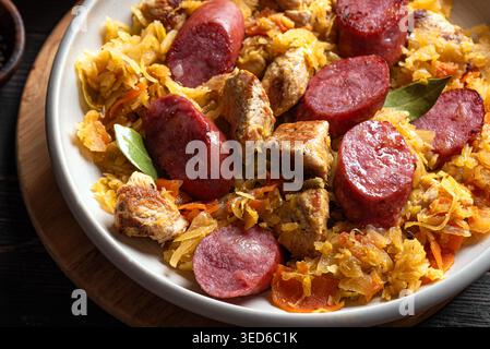Traditionelle polnische Bigos-Mahlzeit oder Hunter's Stew mit Würstchen, Fleisch und gedünstetem Kohl aus nächster Nähe. Hausgemachtes geschmortes Sauerkraut mit Bratwurst. Stockfoto