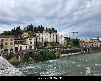 Die Etsch fließt am Hügel von San Pietro vorbei mit dem Castel San Pietro über den Dächern von Verona, Veneto, Italien Stockfoto
