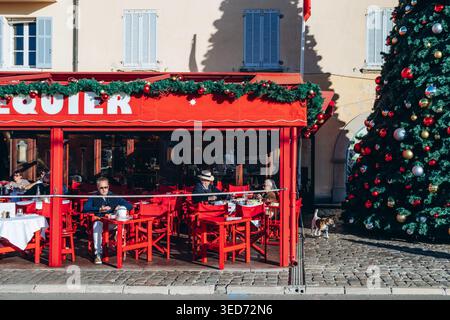 Saint-Tropez, Frankreich - 8. Dezember 2025: Weihnachtsbaum und Senequier Café-Terrasse in Saint-Tropez mit sonnigen Wintertagen auf den Hauptseiten Stockfoto