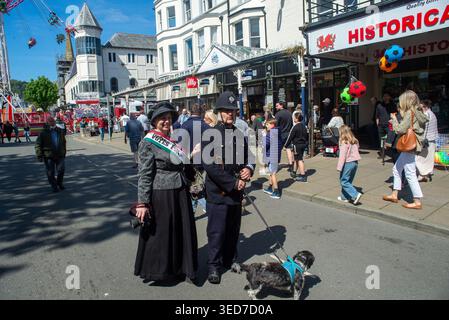 Llandudno, Wales, Vereinigtes Königreich. Mai 2026. Ein Mann und eine Frau, gekleidet als viktorianischer Polizeibeamter und eine Suffragette mit einem „Vots for Women“-Schärpe, posieren für Fotos während der Llandudno Victorian Extravaganza bei sonnigem Bankfeiertag. Die jährliche Veranstaltung bietet historische Kostüme, historische Sehenswürdigkeiten und Straßenunterhaltung in der Küstenstadt. Quelle: Geoff Wedge/Alamy Live News Stockfoto