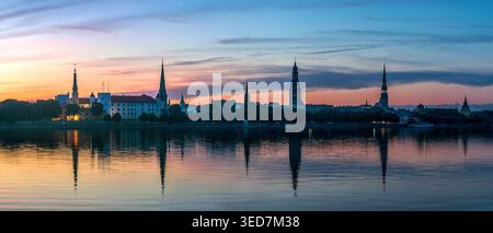 Rigaer Stadtpanorama bei Sonnenaufgang mit Rigaer Burg, Peterskirche, Dom und Akademie der Wissenschaften, Lettland. Malerischer Sonnenaufgang über dem Fluss Daugava Stockfoto