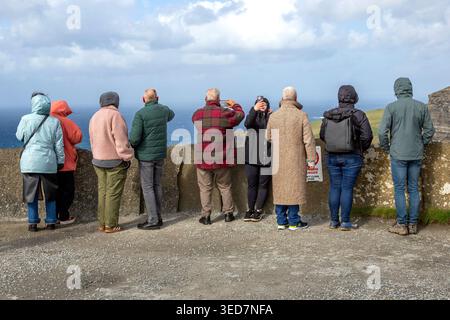 Touristen machen Fotos und Selfies bei einem malerischen Ausblick über den Cliffs of Moher entlang der Westküste Irlands im Atlantik. Stockfoto