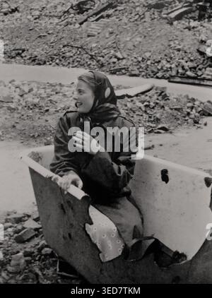 Die schwedische Filmschauspielerin Ingrid Bergman (1915–1982) posiert im Juli 1945 in einem kaputten Bad auf einer Straße in Berlin. Historisches Dokument aus der Zeit des Zweiten Weltkriegs Stockfoto