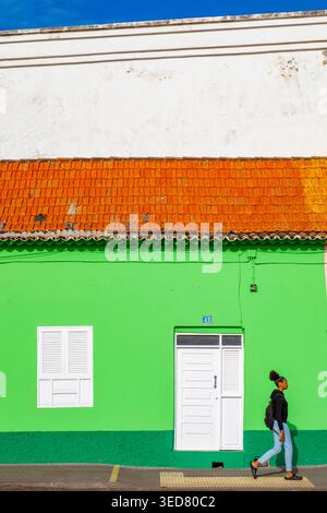 Kap Verde, Santiago, Praia, El Platô, junge Frau vor einer bunten Fassade Stockfoto