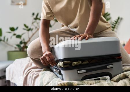 Junge Erwachsene Frau, die den Koffer beim Packen für die Reise zu Hause, Nahaufnahme. Reisevorbereitung und Urlaubsplanung für Tourismusanzeigen, Buchungsservices, Reiseblogs Stockfoto