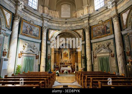 Barocke Inneneinrichtung der Chiesa di Sant'Anna dei Palafrenieri mit polychromen Marmorsäulen, vergoldetem Hochaltar und Holzbänken, Vatikan, Rom, Italien Stockfoto