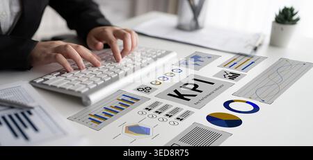 Ein Geschäftsexperte, der sich auf die Analyse von Leistungsindikatoren mit Berichten und visuellen Datendarstellungen in einem modernen Arbeitsbereich mit konzentriert Stockfoto
