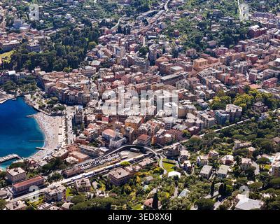Blick aus der Vogelperspektive auf Santa Margherita Ligure mit seinen farbenfrohen mediterranen Gebäuden, kleinem Sandstrand und üppigen grünen Hügeln mit Blick auf das blaue Meer San Stockfoto