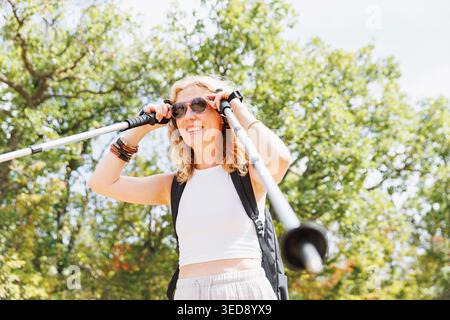 Verstellbare Happy Hiker Sonnenbrille mit Trekkingstöcken bei Sonnenlicht Stockfoto
