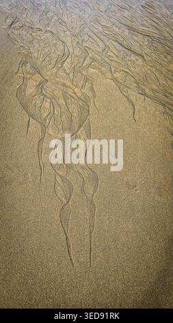 Natürliche Muster, die durch Wasser am Strand des Atlantischen Ozeans bei Ebbe entstehen Stockfoto