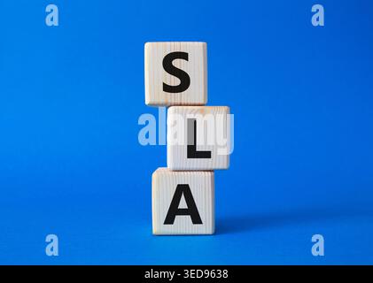 SLA - Service Level Agreement. Holzwürfel mit Wort SLA. Wunderschöner blauer Hintergrund. Business- und Service Level Agreement-Konzept. Kopierbereich. Stockfoto