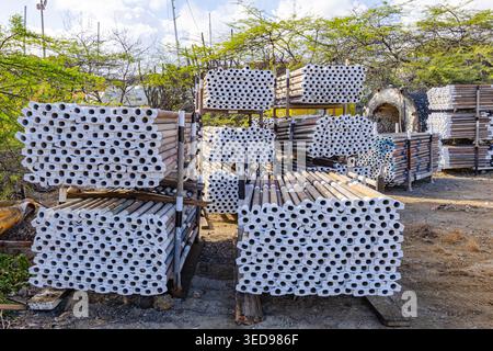 Stapel von Gerüstrohren aus Stahl und Metallkonstruktionen auf einem Außenlagerhof Stockfoto