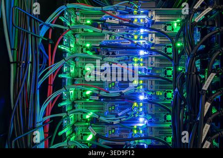 Eine detaillierte Ansicht eines Server-Racks mit beleuchteten Komponenten. Die leuchtenden Kabel und Lampen sorgen für ein geordnetes Erscheinungsbild für modernes Datenmanagement Stockfoto