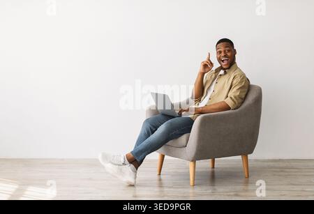 Schwarz Kerl Mit Laptop Mit Idee Sitzen Im Stuhl Drinnen Stockfoto