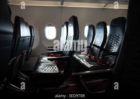 Leere Passagiersitze in der Kabine. Verlassene Sitzreihen in der Economy Class. Stockfoto