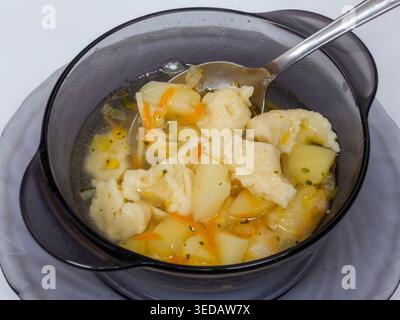 Klöße in Suppe hausgemacht auf weißem Hintergrund Stockfoto