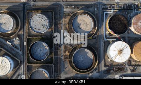 Aus der Vogelperspektive großer kreisförmiger industrieller Lagertanks und komplexer Rohrleitungssysteme in einer Ölraffinerie in Cagliari, Sardinien, Italien. Stockfoto