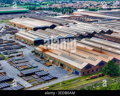 Aus der Vogelperspektive des riesigen Industriekomplexes und der Produktionsanlage für Stahlrohre mit großen Lagerhäusern und Lagerhallen in Dalmine, Lombardei, Italien. Stockfoto