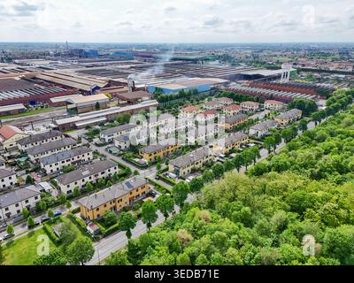 Luftaufnahme des Industriekomplexes und Wohnviertels mit Häuserreihen und grünen Bäumen in Dalmine, Lombardei, Italien. Stockfoto