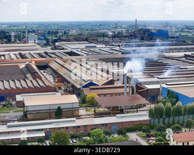 Aus der Vogelperspektive auf den riesigen Industriekomplex und das Stahlwerk mit Rauchschornsteinen und Lagerhausdächern in Dalmine, Lombardei, Italien. Stockfoto