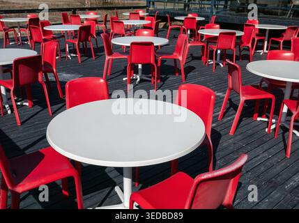 Leere Cafe-Terrasse mit Plastiktischen und -Stühlen im Freien Stockfoto