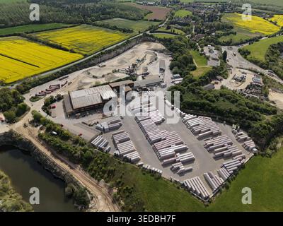 Aus der Vogelperspektive auf Marshalls Maltby Industriegelände mit Betonblöcken und Fabrikgebäuden, umgeben von lebhaften gelben Rapsfeldern Stockfoto