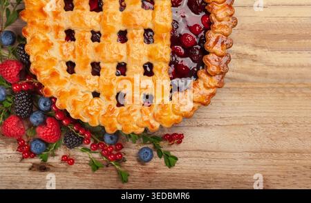 Hausgemachter Sommerbeerkuchen auf rustikalem Holzhintergrund mit Kopierbereich. Draufsicht. Stockfoto