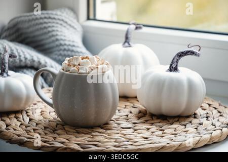 Herbstliche Schokolade oder Kaffee mit Marshmallows und Zimt auf der Fensterbank. Herbstgetränk. Nahaufnahme. Stockfoto