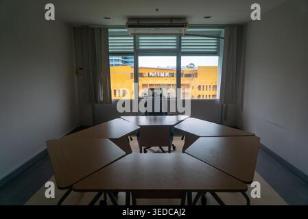 Ein geräumiger, leerer Konferenzraum mit minimalistischem Design und großem Fenster. Die Umgebung betont Klarheit und Ruhe, perfekt für Reflexe Stockfoto