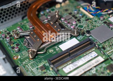 Nahaufnahme einer komplexen Computerplatine mit Komponenten, Prozessorinstallation und Kühlsystemen. Ideal für Technologie und Elektronik Stockfoto