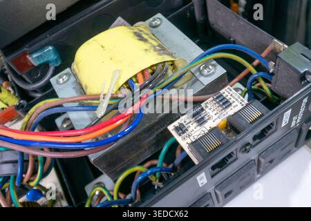 Nahaufnahme einer komplexen Anordnung von bunten Drähten und Schaltungskomponenten, die die komplizierten Details von elektrischen Verbindungen und Technologie zeigen Stockfoto