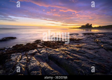 Dramatischer Blick auf Bamburgh Castle an der Northumberland Coast bei Sonnenaufgang, Nordostengland, Großbritannien. Stockfoto
