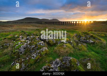 Sonnenuntergang am Ribblehead Viaduct mit dramatischem Blick auf Ingleborough in den Yorkshire Dales, Großbritannien. Stockfoto