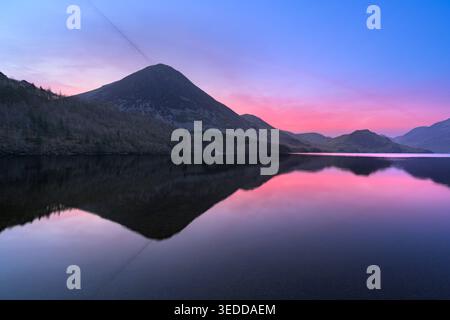 Rosafarbene Sonnenaufgangsreflexe von Grasmoor am Crummock Water im Lake District, Großbritannien. Stockfoto