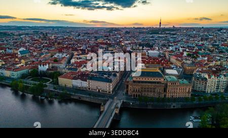 Luftaufnahme des Nationaltheaters und der roten Dächer entlang der Moldau bei Sonnenaufgang in Prag, Prag, Tschechien. Stockfoto