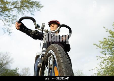 Selbstbewusste junge Radfahrerin mit Lenker und Blick in die Distanz. Stockfoto