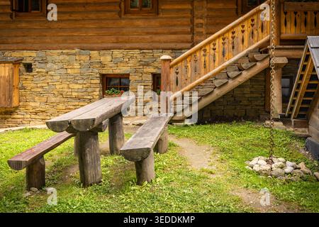 Rustikaler, einfacher Sitzbereich mit Holzbänken und Tisch Stockfoto