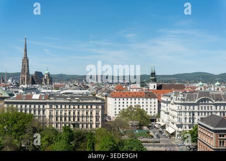 Blick aus der Vogelperspektive auf den Stephansdom und die historische Skyline mit grünen Bäumen und traditioneller Architektur unter einem klaren blauen Himmel in Wien, Wien Stockfoto