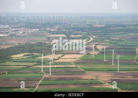 Luftaufnahme von Windturbinen, die auf ausgedehnten landwirtschaftlichen Feldern und grünen Wiesen unter klarem Himmel stehen Niederösterreich, Österreich. Stockfoto