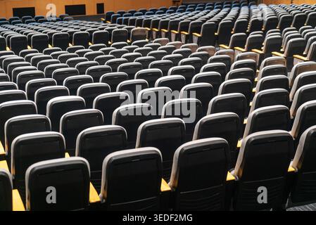 Dieses Bild zeigt eine Reihe leerer Theatersitze, die in ordentlichen Reihen angeordnet sind und die geräumige und organisierte Umgebung eines modernen Auditoriums hervorheben Stockfoto