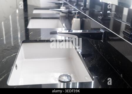 Elegantes, modernes Waschbecken im Badezimmer mit minimalistischem Design, Marmorplatte und elegantem Wasserhahn, perfekt für gehobene Innenräume und Hygiene. Stockfoto