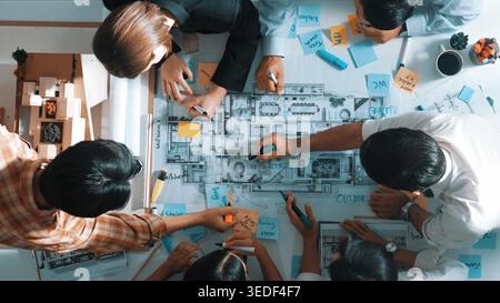 Draufsicht des Projektmanagers oder Bauingenieurs, der bei der Planung des Bauplans und der Gebäudeplanung schreibt. Luftaufnahme eines Architekten, der bei arbeitet Stockfoto