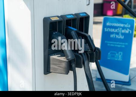 Nahaufnahme einer Ladestation für Elektrofahrzeuge mit Steckverbindern und Netzsteckern, die zum Aufladen von Elektroautos erforderlich sind. Ideal für Techno Stockfoto