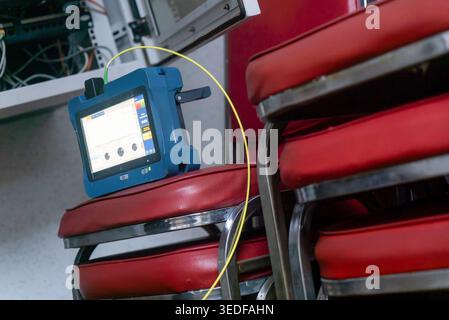 Ein Hightech-Gerät liegt in einer modernen Büroumgebung auf einem Stapel roter Stühle auf und bietet innovative Technologien und Funktionen für Datenmessungen Stockfoto