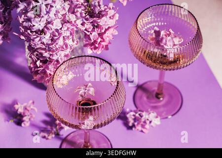 Sektgläser und Fliederblüten in Overhead-Komposition Stockfoto