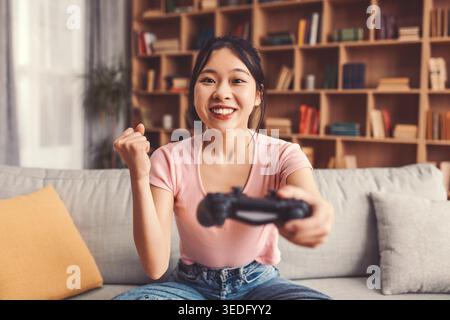 Junge Frau genießt das Spielen zu Hause mit Spannung an einem lustigen Nachmittag Stockfoto